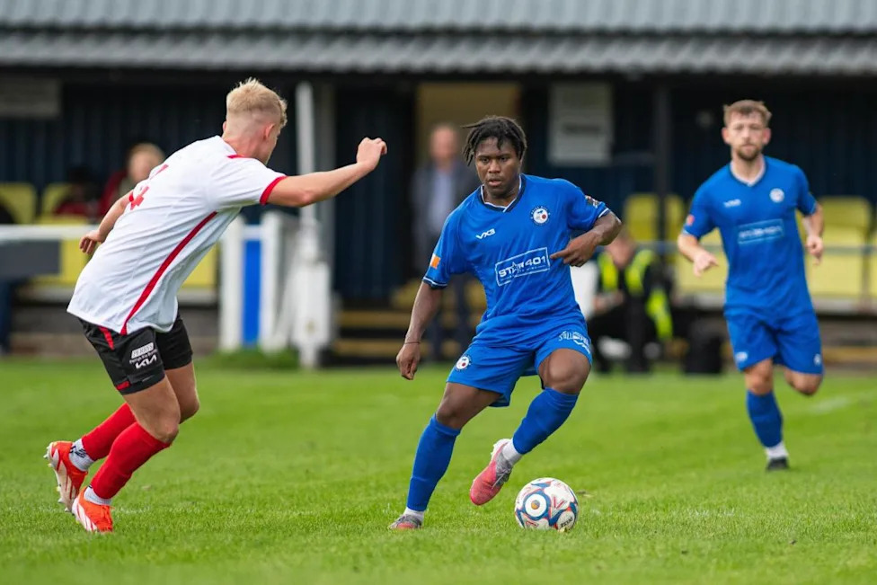 Jelanil Blake enfrenta Joseph Pennington do Colne enquanto Ollie Partington olha (Imagem: Max Healey)