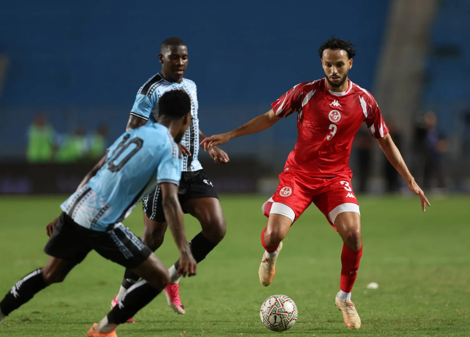 Tunisia's Montassar Talibi (R) fights for the ball with player of Botswana's Thero Setsile (L)